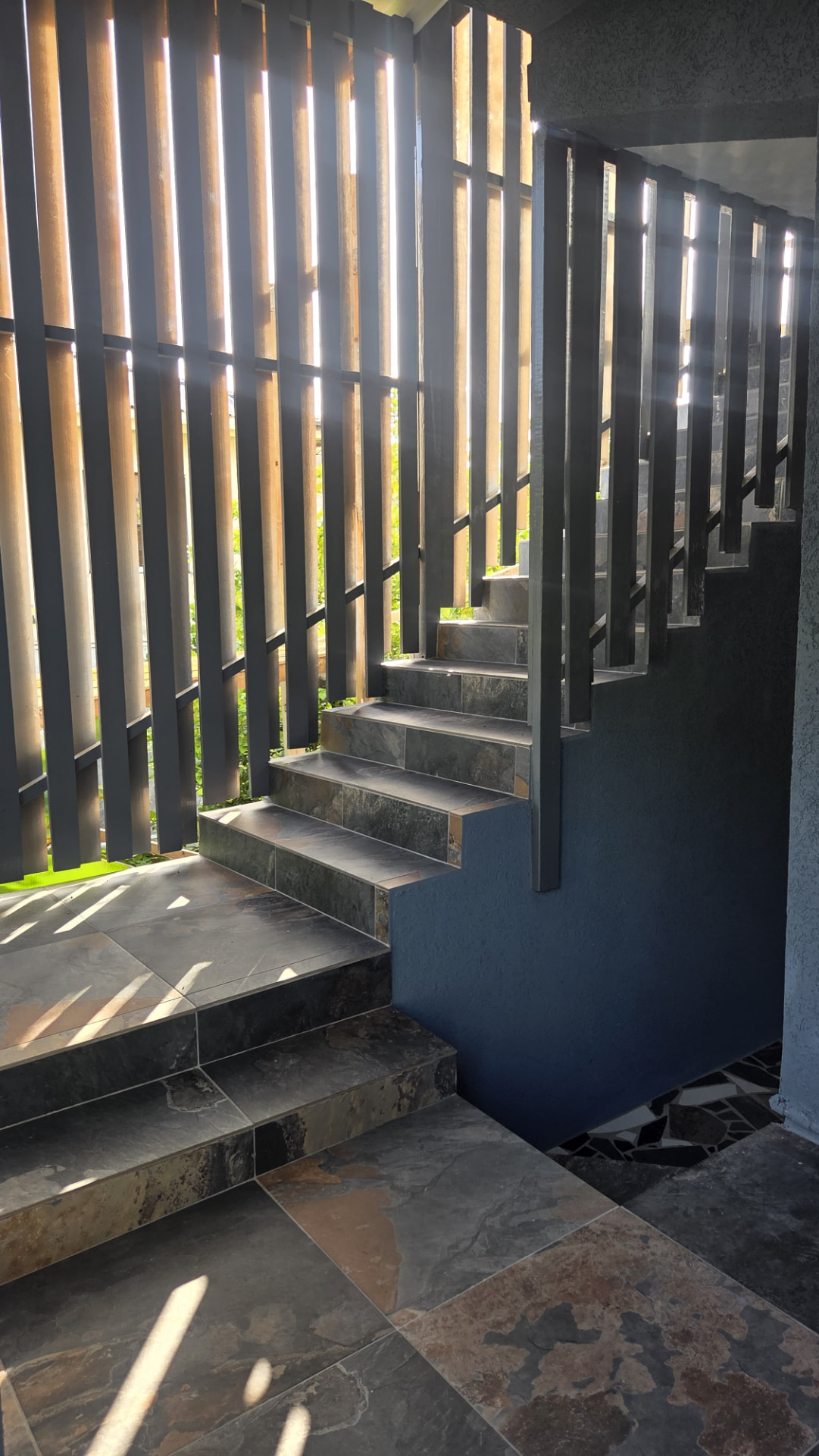 Stone-tiled stairs and tropical planting at the entrance to Azure Breeze Apartment